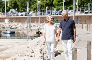 Retired couple walking in marina.png