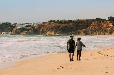 Senior couple walking on Falesia Beach in Algarve.jpg