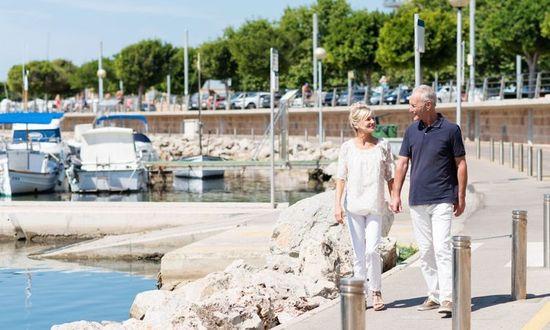 Retired couple walking in boat marina.jpg